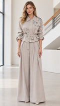 Front full view of woman wearing taupe crystal embellished belted jacket and wide-leg trousers set