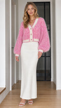 Model wearing pink fuzzy knit cropped cardigan with white maxi skirt, front view