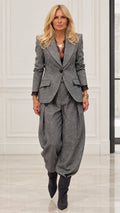 Model wearing Grey herringbone blazer and pleated balloon trousers two-piece suit set with lace cuffs