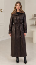 Front view of model wearing dark brown faux leather maxi trench coat with plush collar