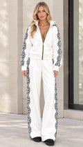 Front view of model wearing white two-piece tracksuit set with black lace side trim