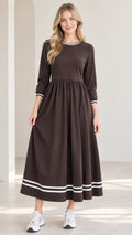 Front view of woman wearing brown 3/4 sleeve maxi dress with white striped trim