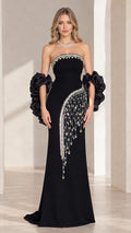 Front view of black strapless column gown with beaded fringe and ruffled arm cuffs
