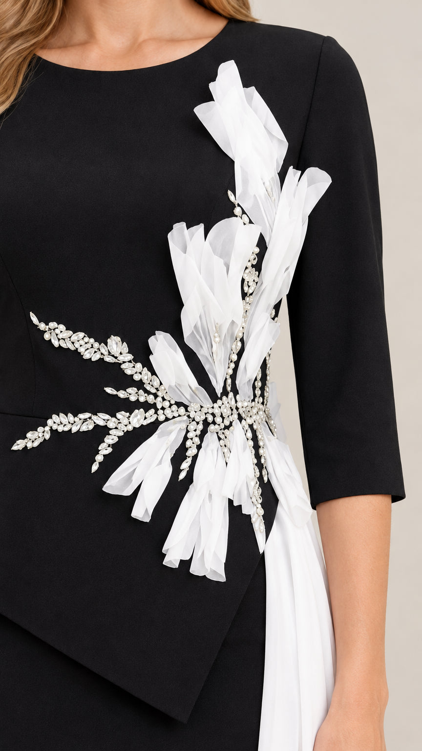 Close-up detail of 3D white floral petals and intricate crystal beadwork on black evening gown