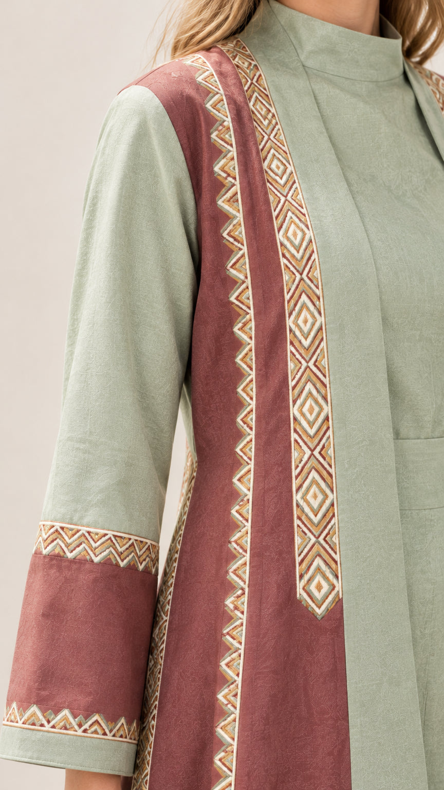 Close-up detail of geometric embroidered trim on abaya collar and sleeve cuff